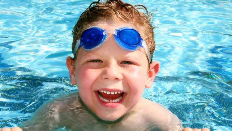 child in pool swimming 
