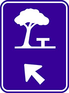 blue sign with white icon of a picnic table under a tree and an arrow
