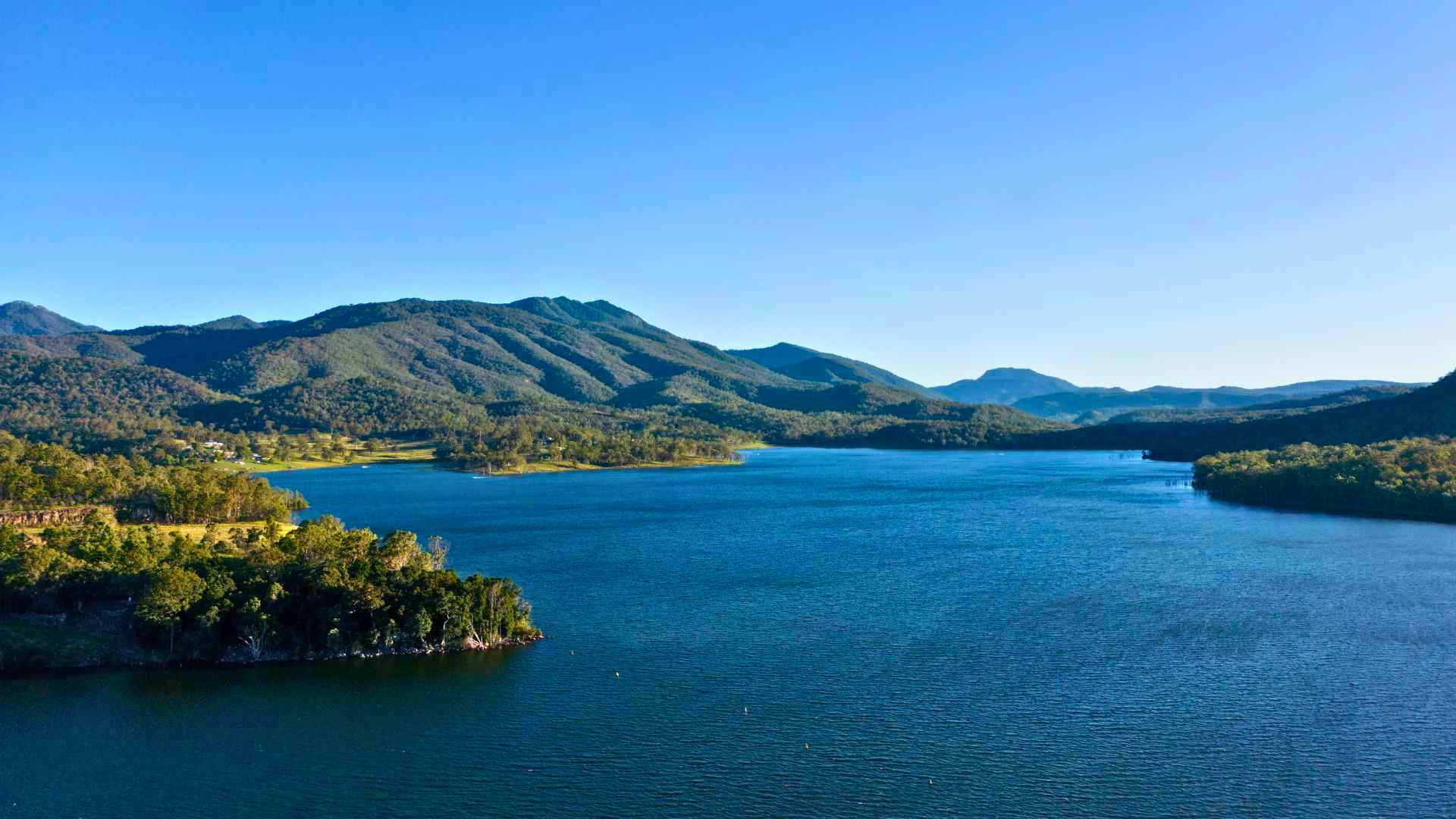 Aerial view of Maroon Dam with surrounding mountains and forests.