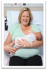 Mother holding her baby across her body with one arm, in a cradle hold.