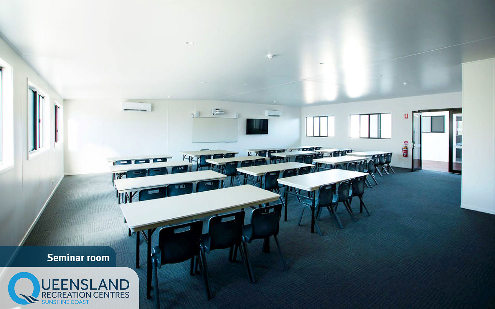 Shelly’s seminar room setup with many tables and chairs facing a whiteboard and television at the Sunshine Coast Recreation Centre.