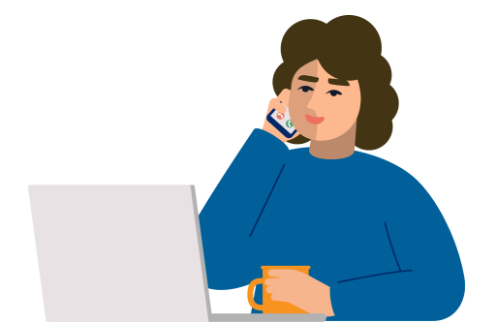 A woman is smiling while talking on the telephone. She's seated at her computer with a cup of tea.