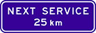blue sign with white text, next service 25km