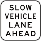 white sign with black text, slow vehicle lane ahead