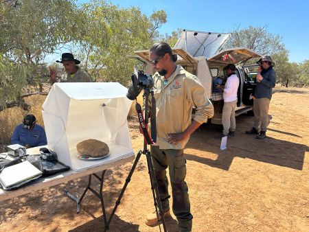 Rangers working with field equipment under shady trees