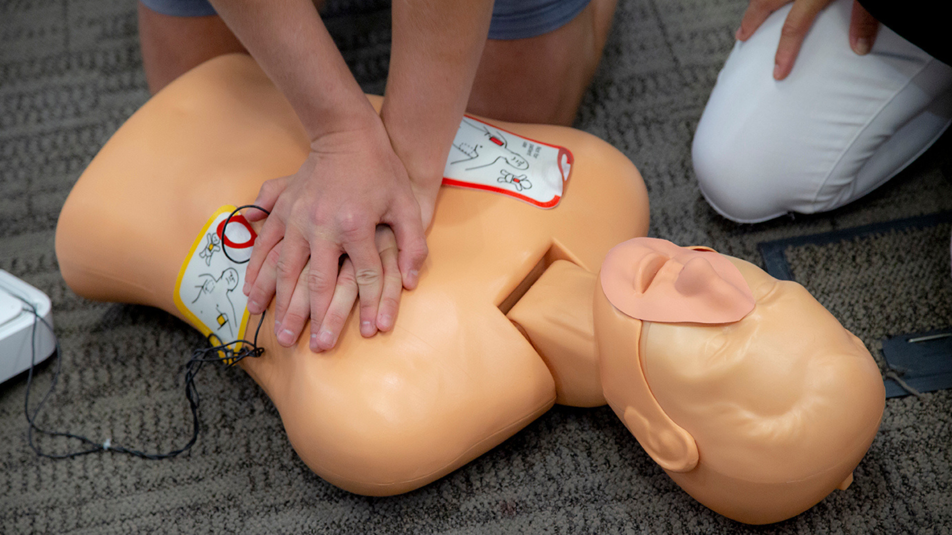 Photo of an AED being used on a manikin for training