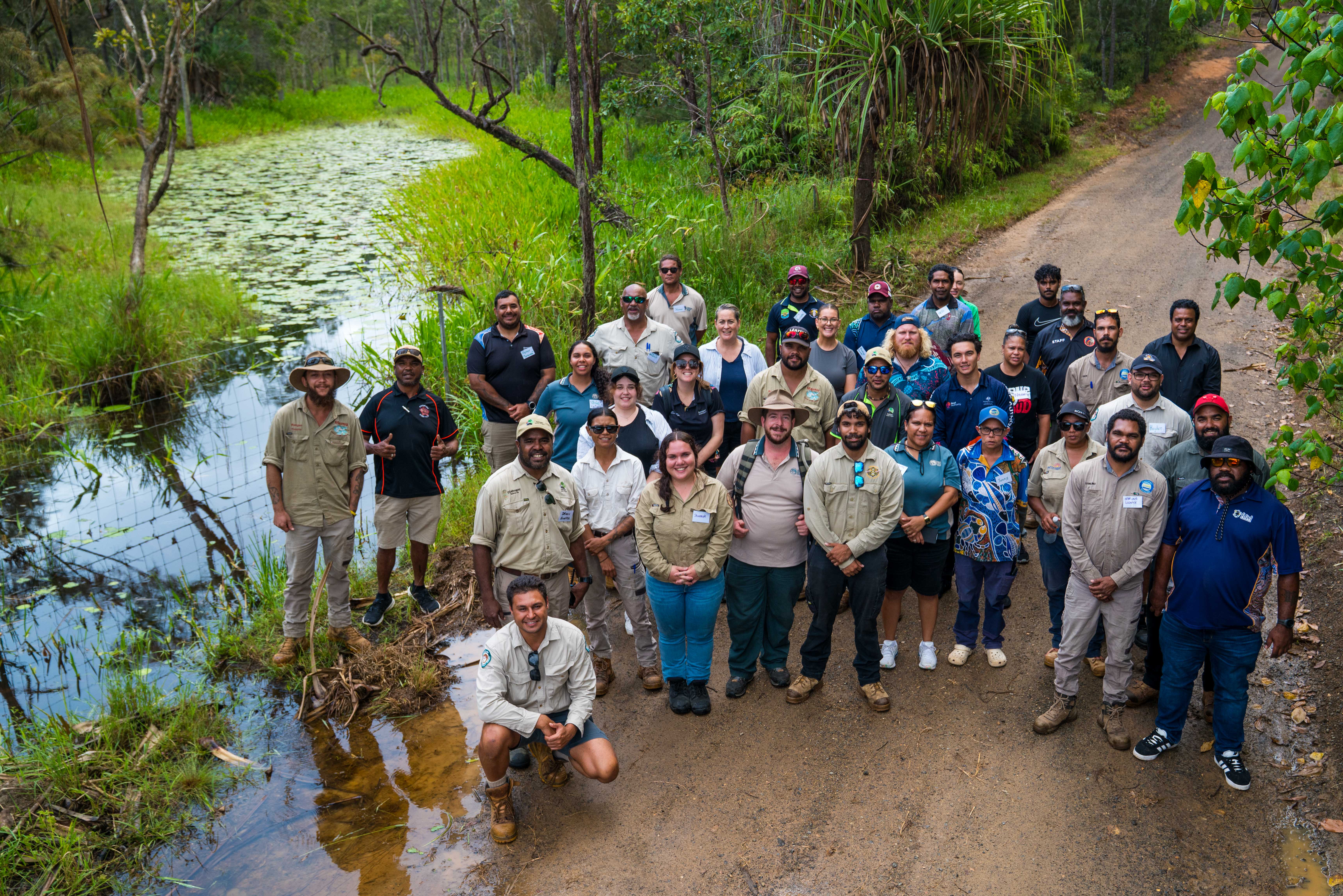 Group of rangers pose for camera near a wetland