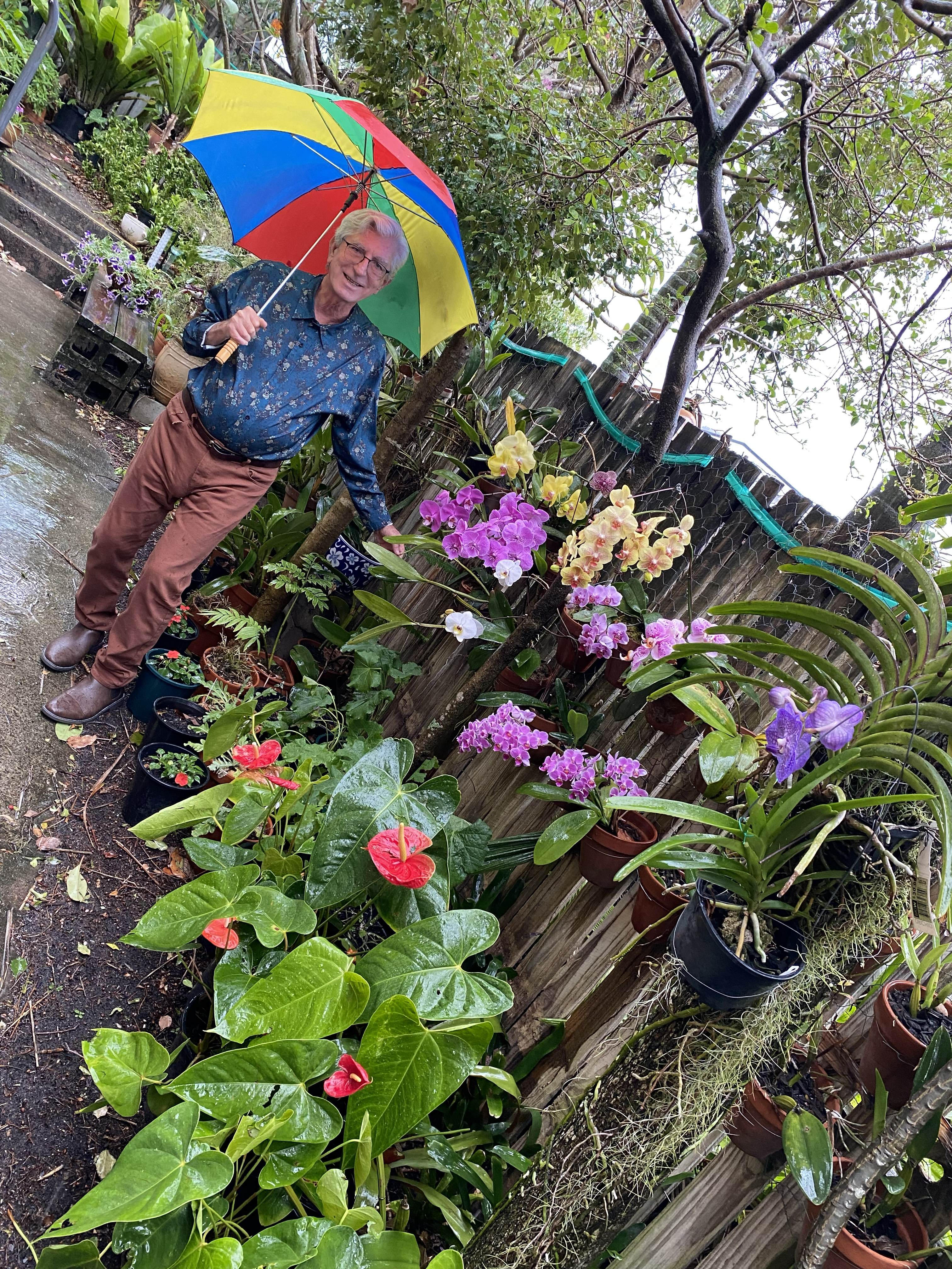 man with umbrella standing in garden