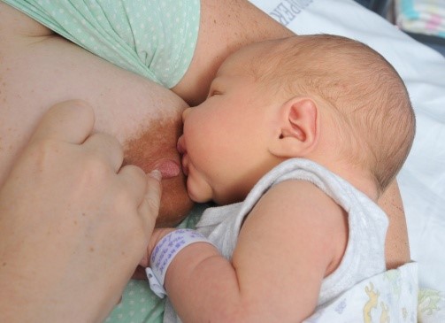 Baby at the breast with nipple being removed from baby’s mouth by the mother.