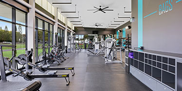 Interior view of the gym with machines and shelving to store belongings.