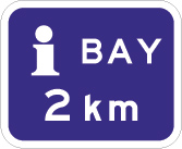 blue sign with a white letter i and the text bay 2km