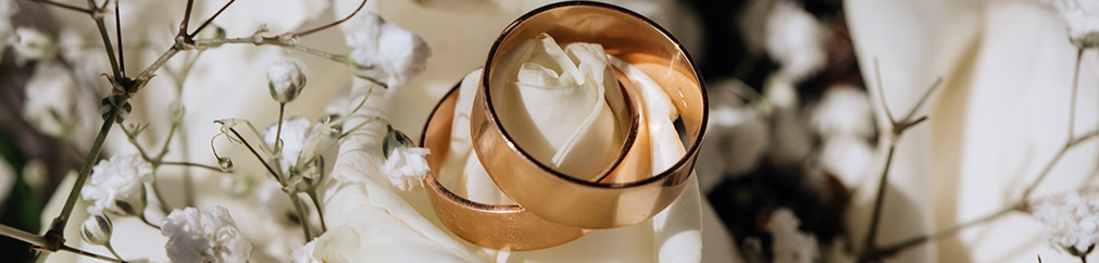 Wedding rings displayed on white flowers