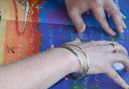 Karen Knight’s fingers brush across a children’s book open on her lap, as she reads the raised words formed in Braille.