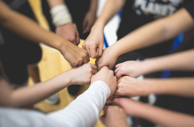 lots of hands in fist creating a circle