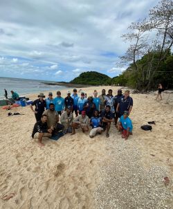 Group of people pose for camera on an island beach