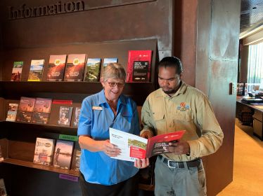 Photo of Lake Eyre Basin ranger explaining brochure to a volunteer in the Waltzing Matilda Centre, Winton.