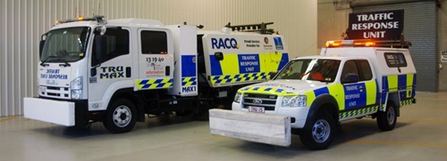 Traffic response unit truck with TRU signage and highly visible, bright yellow and blue block patterns. A second smaller vehicle with similar signage and red flashing lights