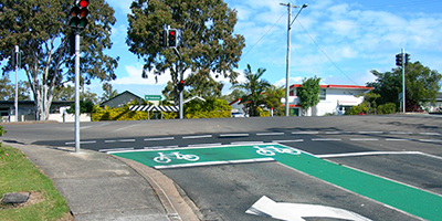 bicycle storage area, an intersection with green painted areas and white bicycle symbols