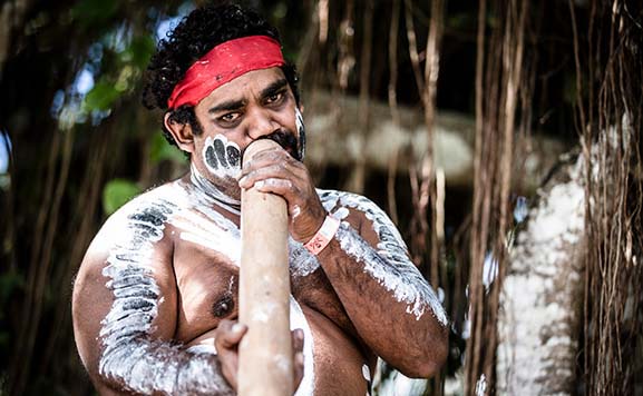Indigenous man playing the didgeridoo
