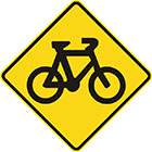 yellow diamond-shaped sign with black image of a bicycle