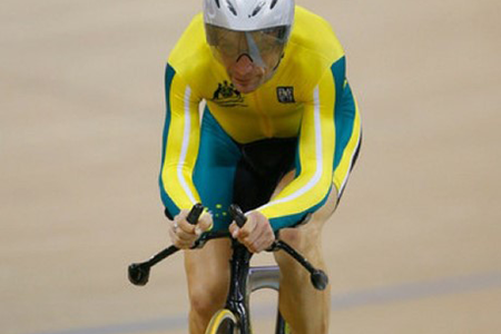 A person racing a bicycle on a velodrome.
