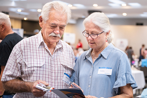 Man and woman at Seniors Expo looking at brochures they have been given.