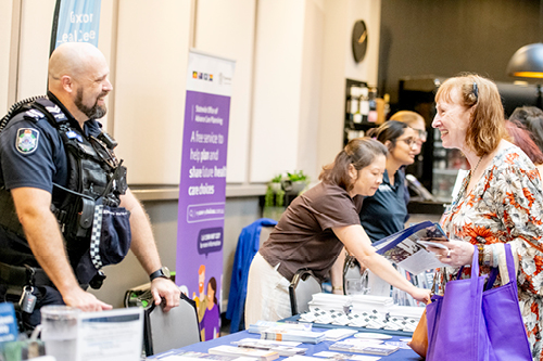 Woman talking to male police officer at a Seniors Expo.