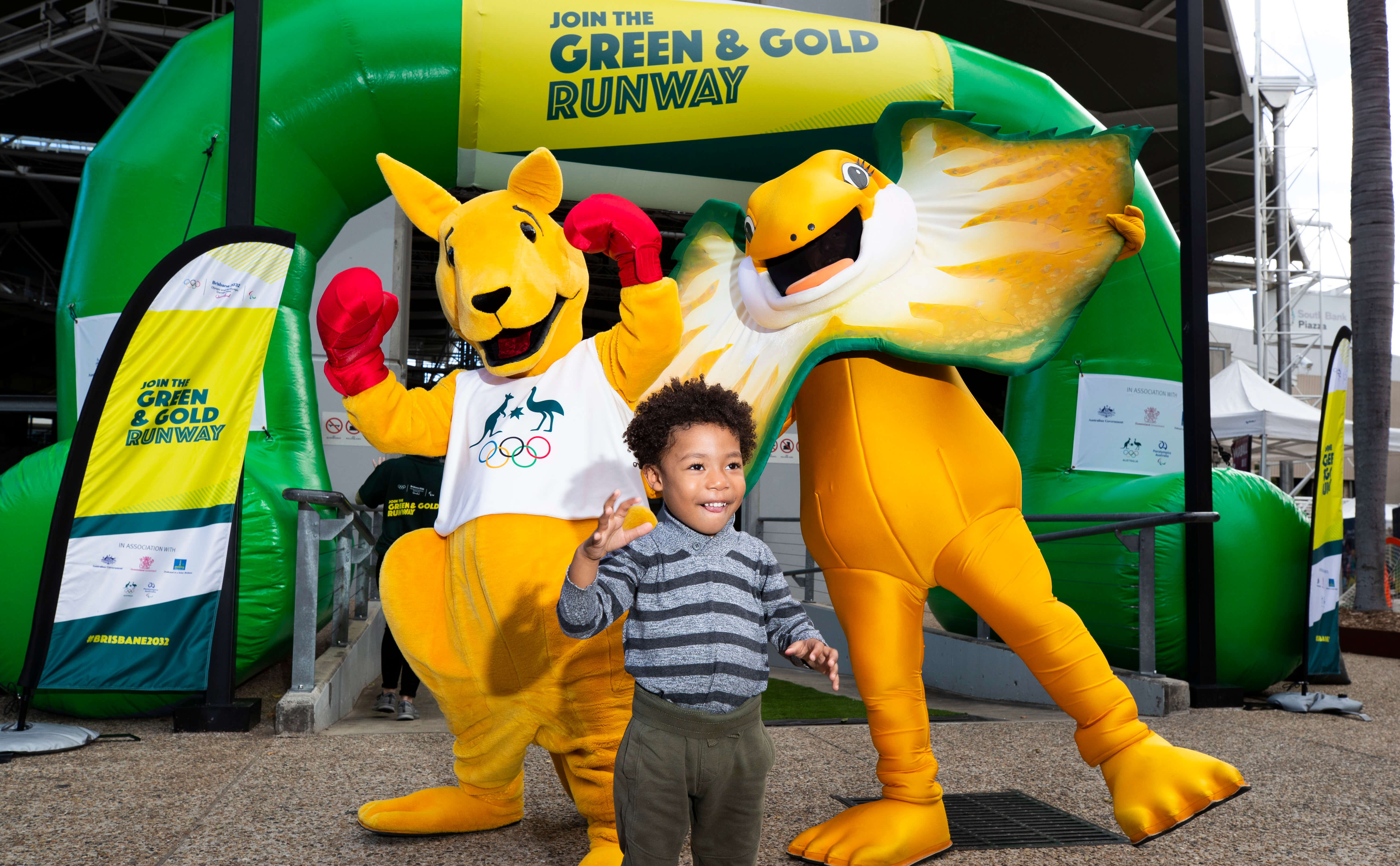 Happy little boy with Australian mascots kangaroo and frill-neck lizard